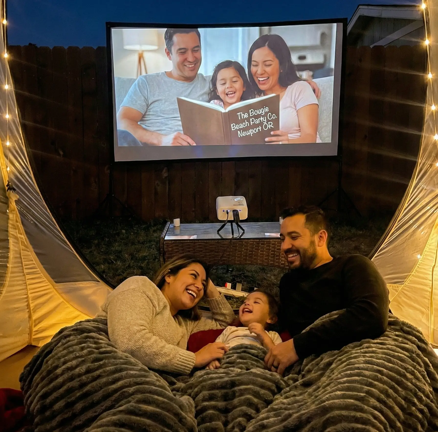 Family outdoor movie night inside clear bubble dome near Newport Oregon with blankets and pillows