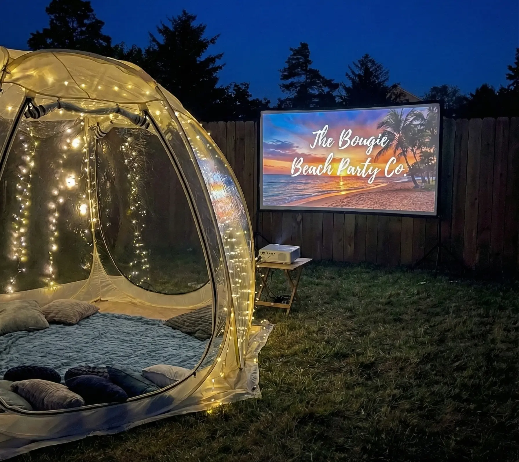 Box Office Bubble movie night setup in Newport Oregon backyard with projector and cozy bedding